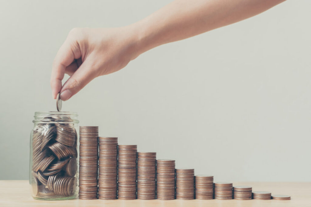 Hand Putting Coins In Jar | Moran Family of Brands